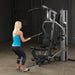 Female athlete doing mid pulley standing rows on Body-Solid G5S Home Gym, pulling handle towards her chest