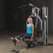 Female athlete doing seated leg extension on Body-Solid G5S Home Gym, extending legs forward