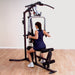 White female athlete performing rows on the Body Solid Home Gym G3S, using the mid-row handles for a back workout.